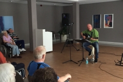 Burkhard Peine spielt Gitarre und singt vor seinen Gästen
