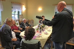 Burkhard Peine spielt Gitarre und singt vor seinen Gästen