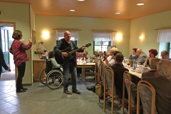 Burkhard Peine spielt Gitarre und singt vor seinen Gästen