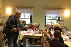 Burkhard Peine spielt Gitarre und singt vor seinen Gästen