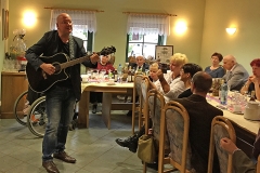 Burkhard Peine spielt Gitarre und singt vor seinen Gästen