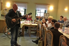 Burkhard Peine spielt Gitarre und singt vor seinen Gästen