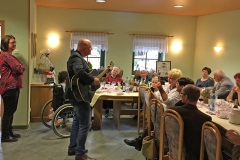 Burkhard Peine spielt Gitarre und singt vor seinen Gästen